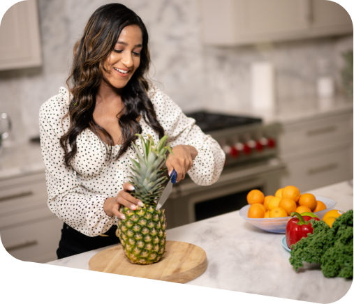 Rakhi cutting a pineapple in her kitchen